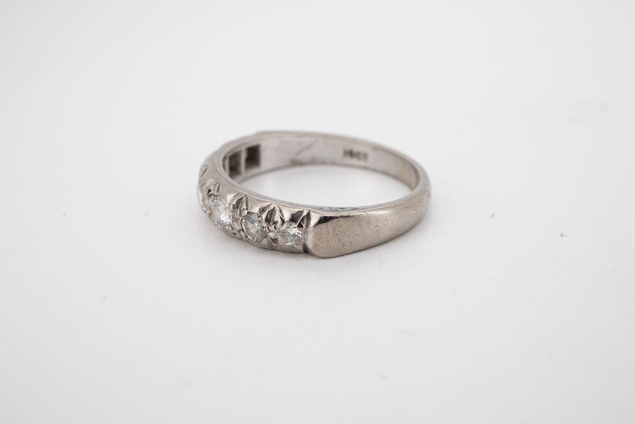 A white metal, (stamped 18ct) and graduated seven stone diamond set half hoop ring, size M.